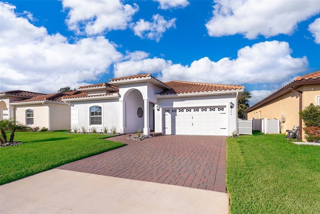 mediterranean / spanish house with a garage and a front lawn