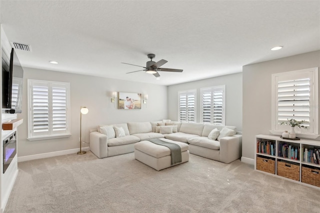 carpeted living area featuring baseboards, visible vents, ceiling fan, and recessed lighting