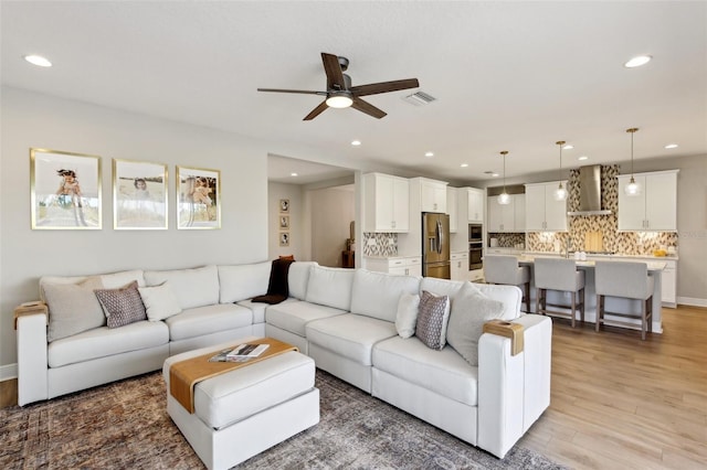 living area featuring recessed lighting, visible vents, light wood-style floors, and ceiling fan