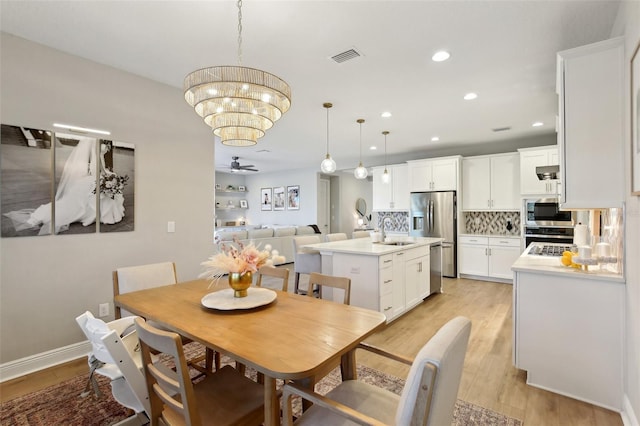 dining area with visible vents, light wood finished floors, baseboards, recessed lighting, and ceiling fan with notable chandelier