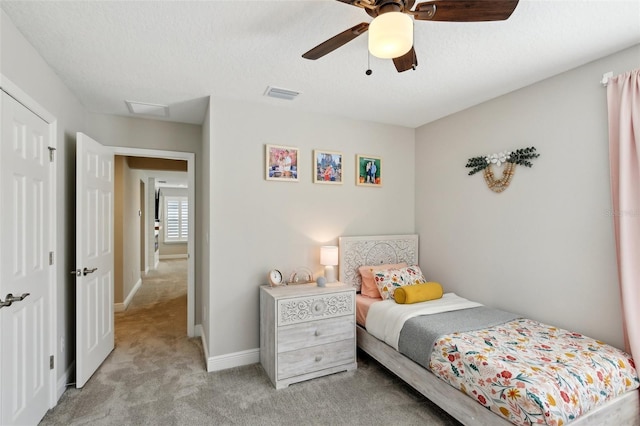 bedroom featuring baseboards, visible vents, ceiling fan, a textured ceiling, and carpet flooring