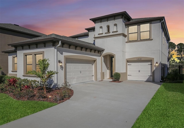 view of front facade featuring concrete driveway, fence, and stucco siding