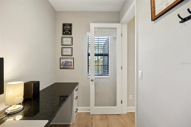 interior space featuring light wood-type flooring and baseboards