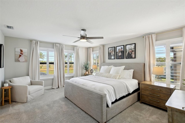 bedroom with a ceiling fan, light colored carpet, and visible vents