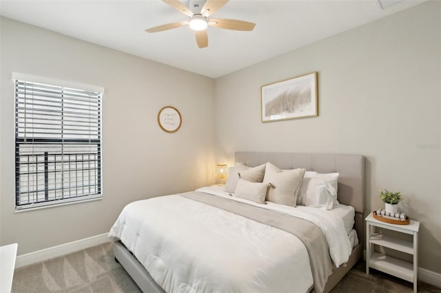 carpeted bedroom with ceiling fan and baseboards