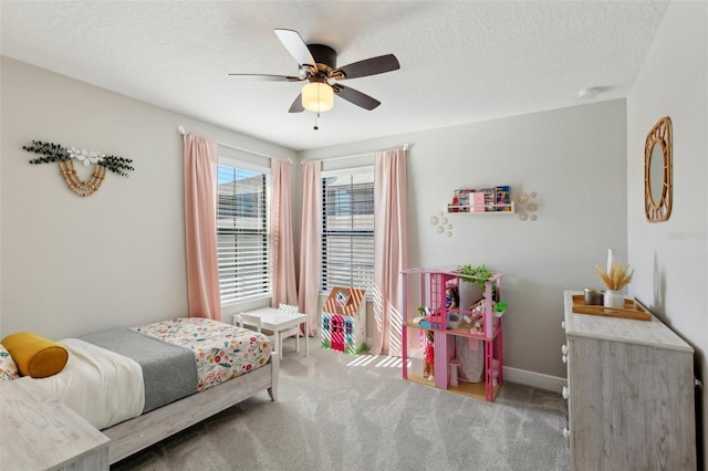 carpeted bedroom featuring a textured ceiling, ceiling fan, and baseboards