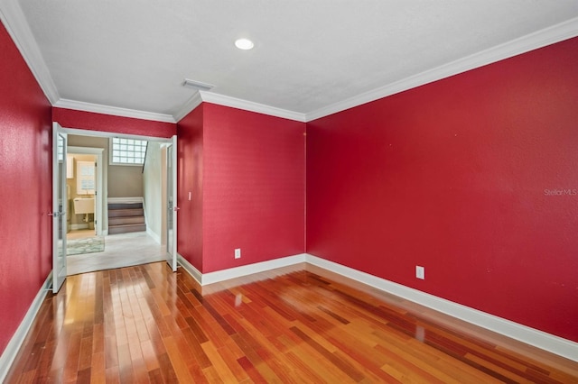 spare room featuring hardwood / wood-style flooring and crown molding