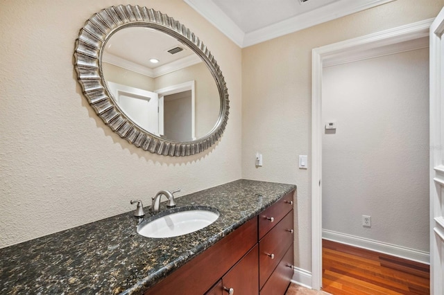 bathroom with vanity, hardwood / wood-style flooring, and ornamental molding