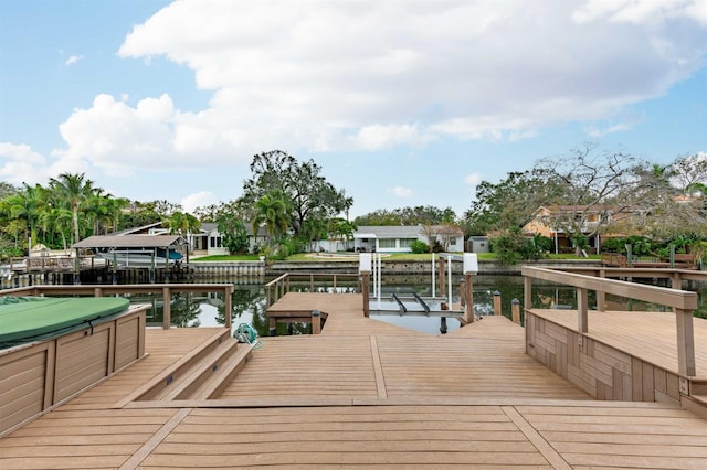 view of dock with a water view and a covered hot tub