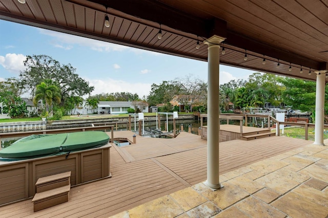 wooden terrace featuring a boat dock and a water view