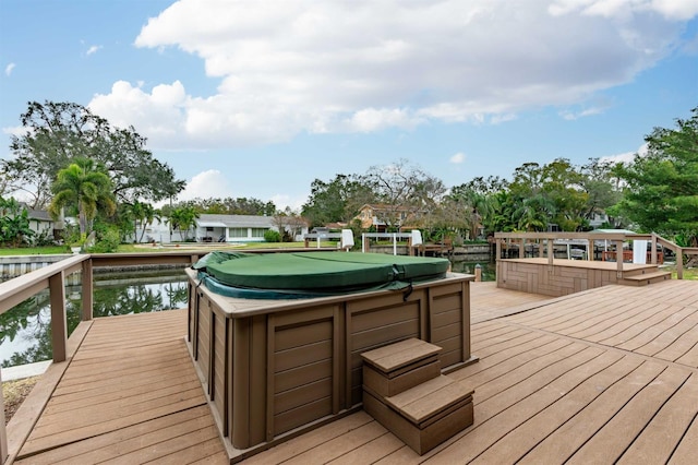 wooden terrace featuring a water view and a hot tub