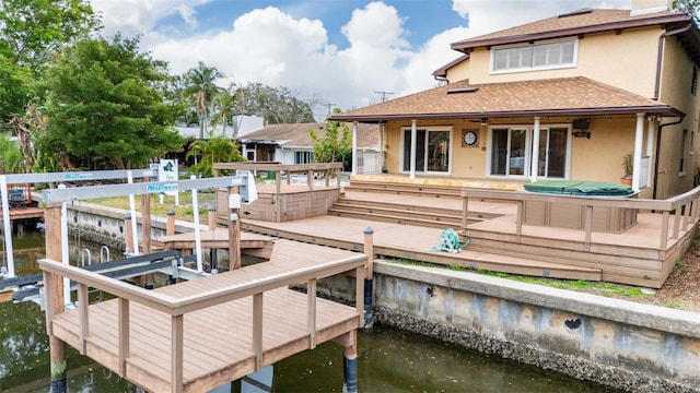 exterior space featuring a water view and a hot tub