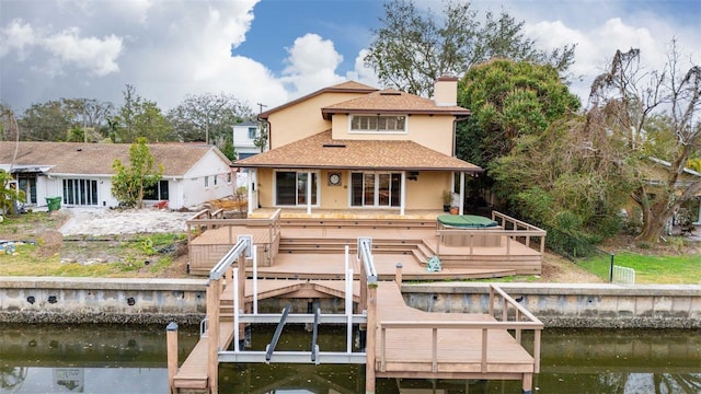 back of property with a deck with water view