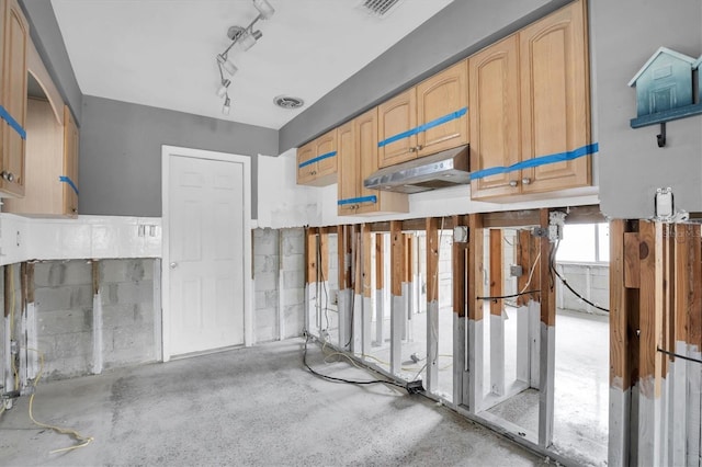 kitchen with concrete floors and light brown cabinets