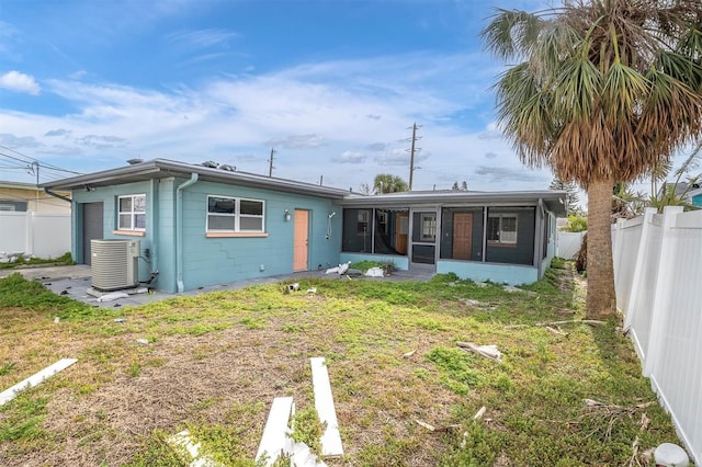 back of property featuring a yard, a sunroom, and central air condition unit