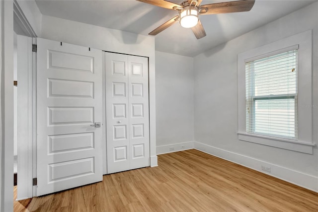 unfurnished bedroom featuring light wood finished floors, baseboards, a closet, and ceiling fan