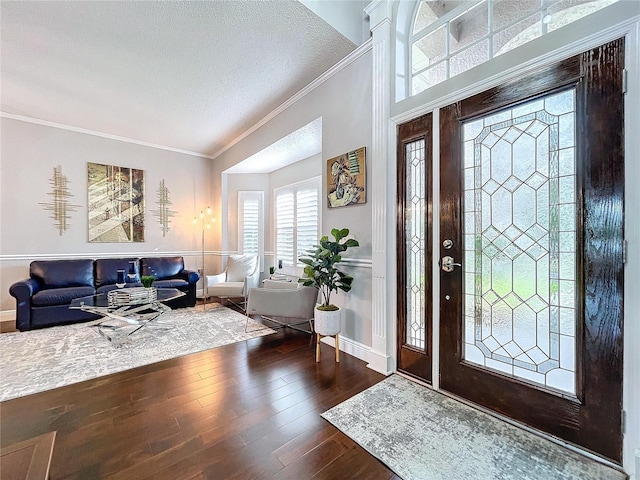 entryway featuring wood-type flooring, ornamental molding, and a textured ceiling