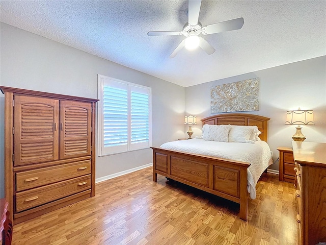 bedroom featuring ceiling fan, a textured ceiling, and light wood-type flooring