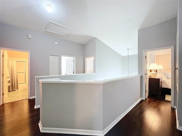 corridor with dark hardwood / wood-style floors and a textured ceiling