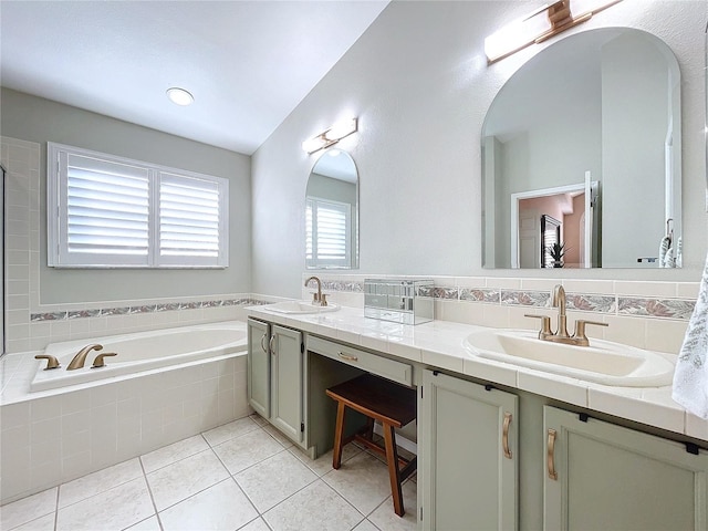 bathroom featuring tile patterned flooring, vanity, and tiled tub