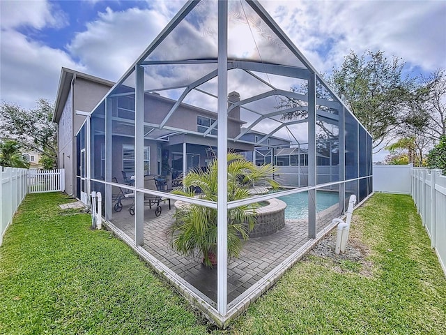 rear view of house with a fenced in pool, a patio, a yard, and glass enclosure