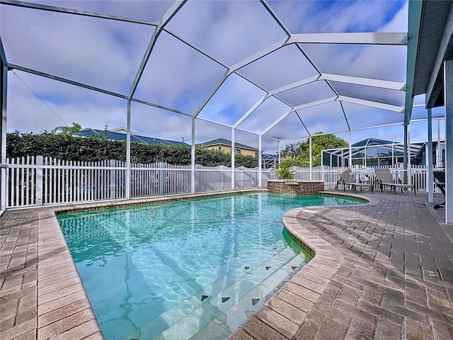 view of swimming pool featuring a lanai and a patio area