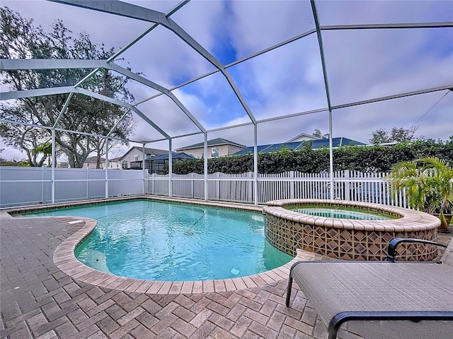 view of pool featuring a lanai, a patio area, and an in ground hot tub