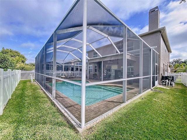 rear view of house featuring a patio, a yard, a fenced in pool, and glass enclosure