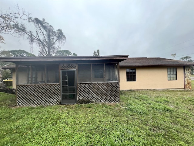 back of property featuring a sunroom and a yard