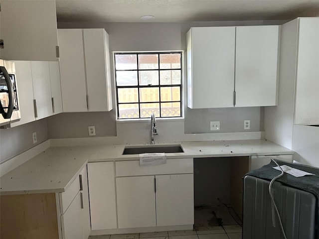 kitchen featuring sink, white cabinets, and light tile patterned flooring