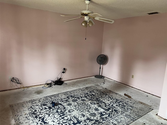 empty room with ceiling fan and a textured ceiling