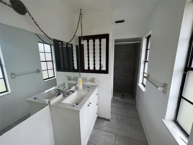 bathroom with vanity, tile patterned floors, and a tile shower