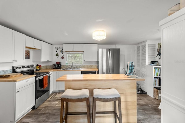 kitchen featuring butcher block counters, sink, stainless steel appliances, and white cabinets