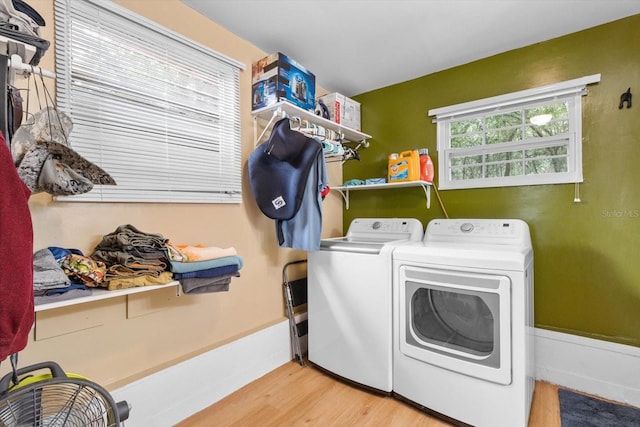 laundry room with independent washer and dryer and light wood-type flooring