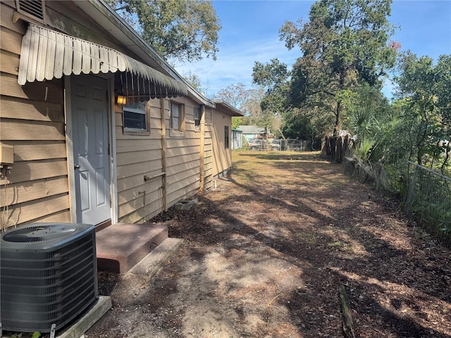 view of side of property featuring fence and central AC unit