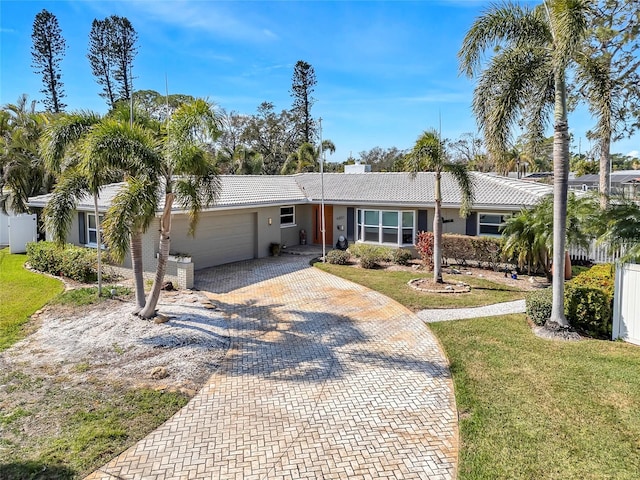 ranch-style home featuring a garage and a front lawn