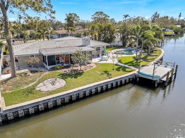 exterior space with a water view, a yard, a patio area, and a sunroom