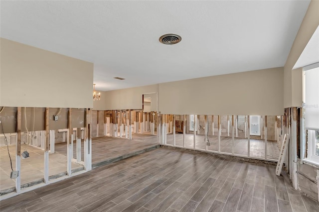 basement featuring hardwood / wood-style flooring and a notable chandelier