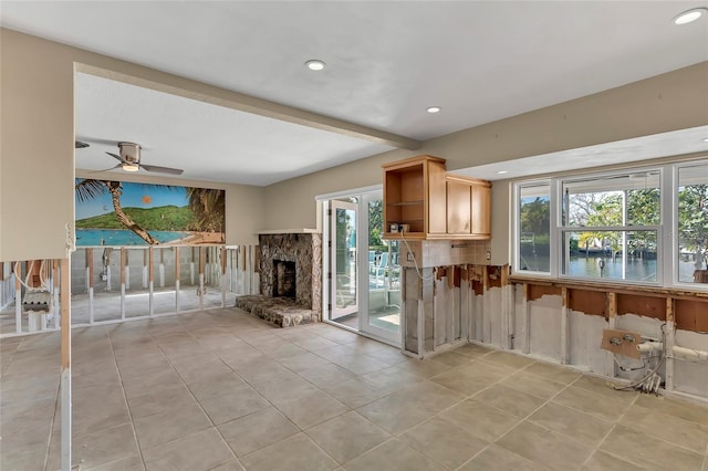 kitchen with ceiling fan, tasteful backsplash, light tile patterned flooring, a stone fireplace, and light brown cabinets