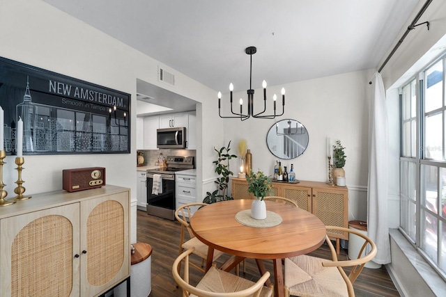 dining space with an inviting chandelier and dark hardwood / wood-style floors