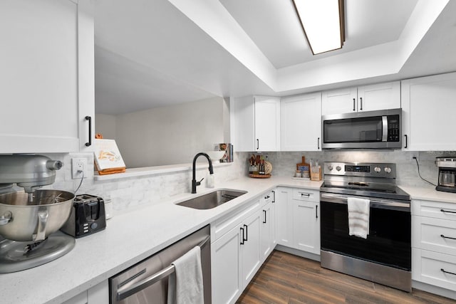 kitchen featuring decorative backsplash, sink, white cabinetry, and appliances with stainless steel finishes