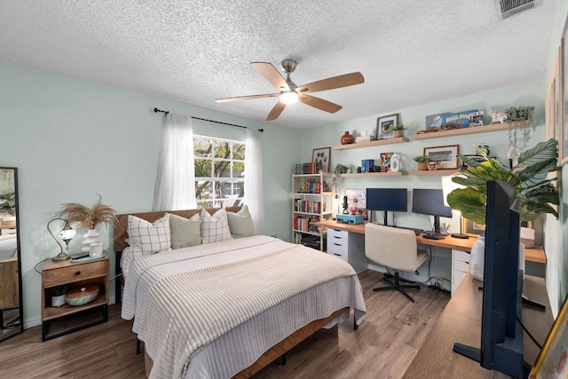 bedroom with hardwood / wood-style floors, a textured ceiling, and ceiling fan