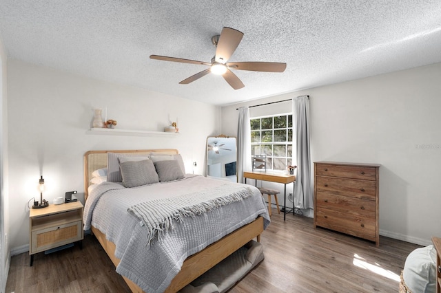 bedroom with ceiling fan, a textured ceiling, and wood-type flooring