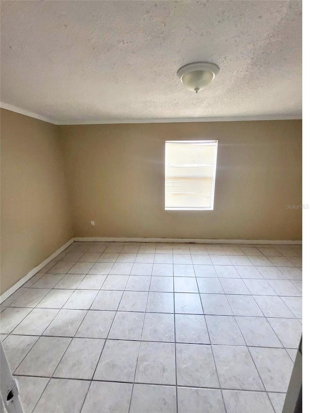 tiled spare room featuring a textured ceiling