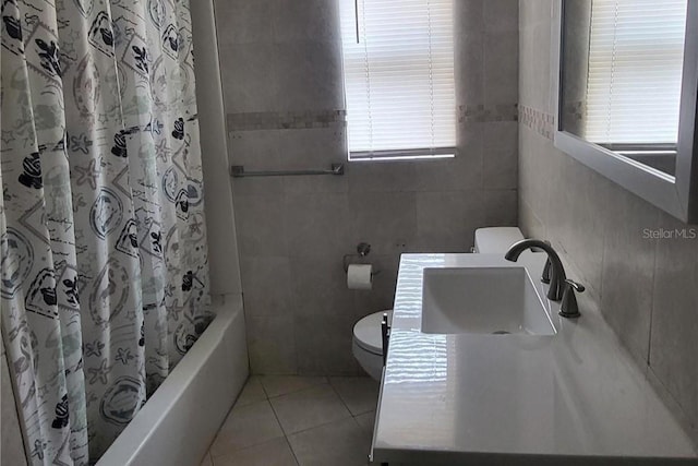 full bathroom with shower / tub combo with curtain, sink, tile walls, tile patterned flooring, and toilet