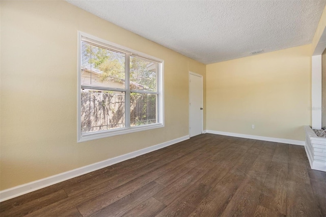 5130 Dr Martin Luther King Jr St S, Saint Petersburg, FL 33705 - empty room featuring dark wood finished floors, a textured ceiling, and baseboards