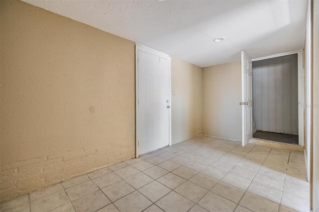 5130 Dr Martin Luther King Jr St S, Saint Petersburg, FL 33705 - empty room featuring light tile patterned floors, a textured ceiling, and a textured wall