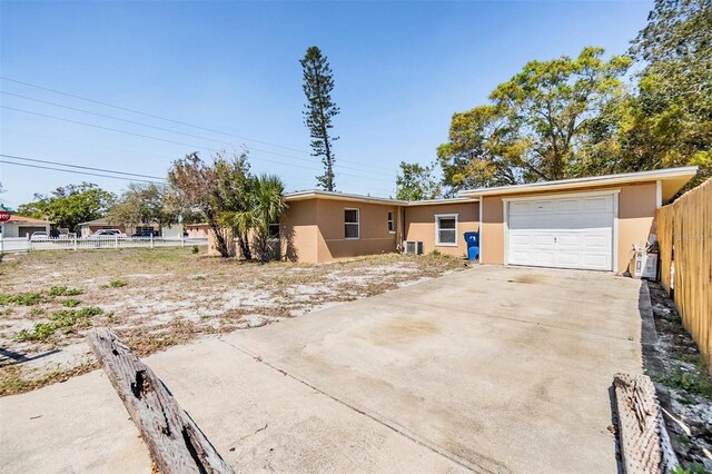 5130 Dr Martin Luther King Jr St S, Saint Petersburg, FL 33705 - ranch-style house featuring stucco siding, an attached garage, concrete driveway, and fence