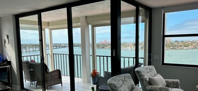 sunroom with a wealth of natural light and a water view