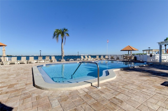 view of swimming pool with a water view and a patio area